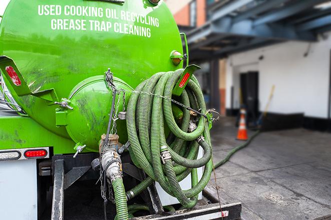 a technician pumping a grease trap in a commercial building in Harwood Heights IL